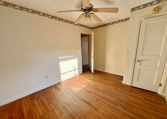 unfurnished bedroom featuring hardwood / wood-style flooring, a textured ceiling, and ceiling fan