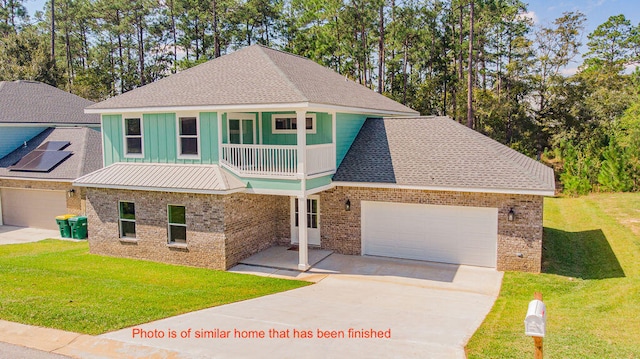 view of front of property featuring a front lawn, a balcony, and a garage