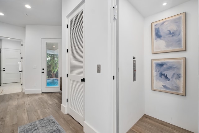 hallway with light hardwood / wood-style floors