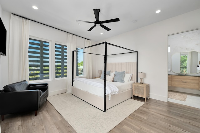 bedroom featuring multiple windows, light hardwood / wood-style floors, and ceiling fan