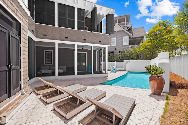 view of pool with a sunroom and a patio area