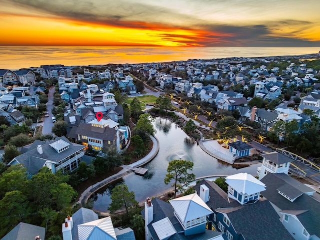 aerial view at dusk featuring a water view