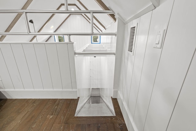 walk in closet with wood-type flooring, visible vents, and vaulted ceiling