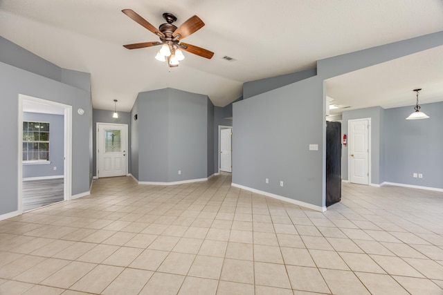 tiled empty room featuring vaulted ceiling and ceiling fan