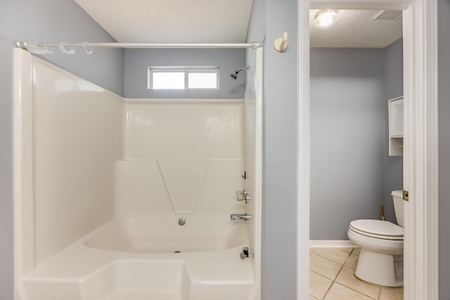 bathroom featuring a textured ceiling, tile patterned flooring, toilet, and shower / bathtub combination