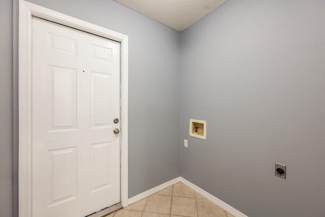 washroom with a textured ceiling, hookup for a washing machine, light tile patterned floors, and electric dryer hookup