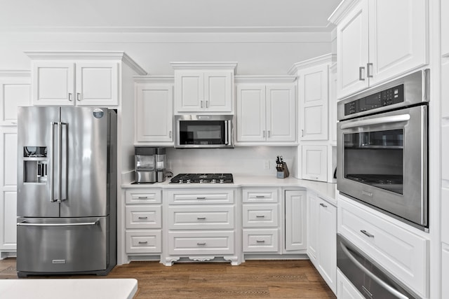 kitchen featuring appliances with stainless steel finishes, white cabinetry, and dark hardwood / wood-style flooring