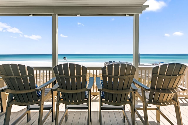 sunroom / solarium with a water view and a beach view