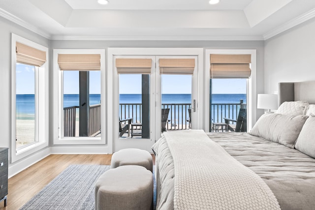 bedroom with a water view, access to exterior, and multiple windows