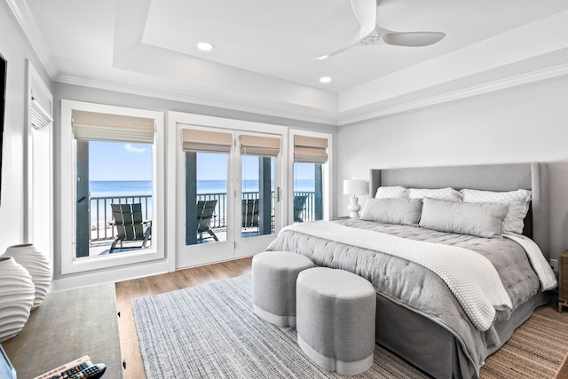 bedroom featuring a water view, ceiling fan, hardwood / wood-style floors, access to outside, and ornamental molding