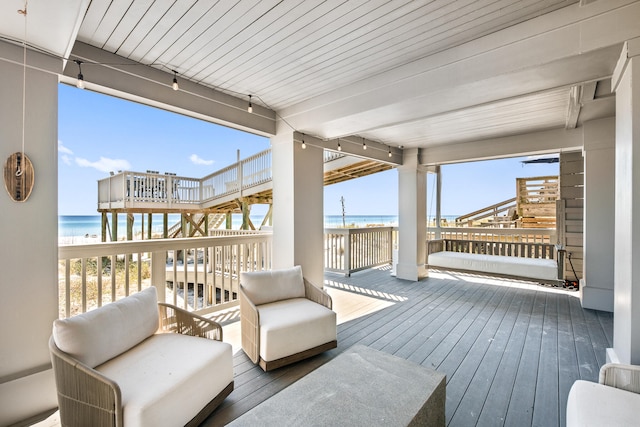 wooden terrace with a water view and a beach view