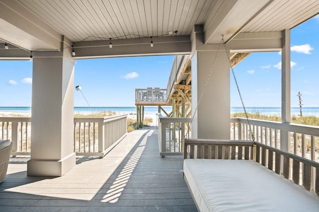 deck featuring a beach view and a water view