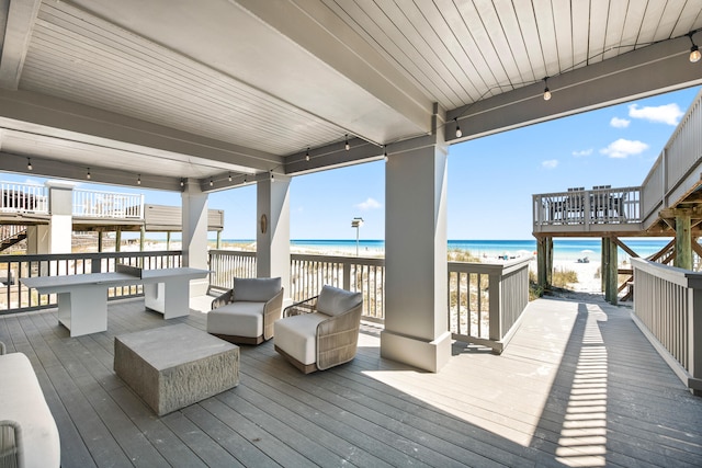 deck with a beach view and a water view