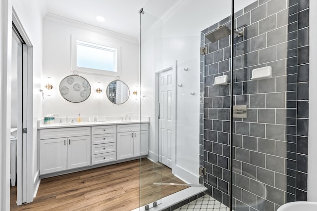 bathroom with ornamental molding, hardwood / wood-style flooring, vanity, and tiled shower