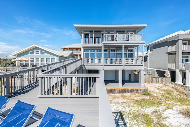 back of property featuring a balcony and a wooden deck