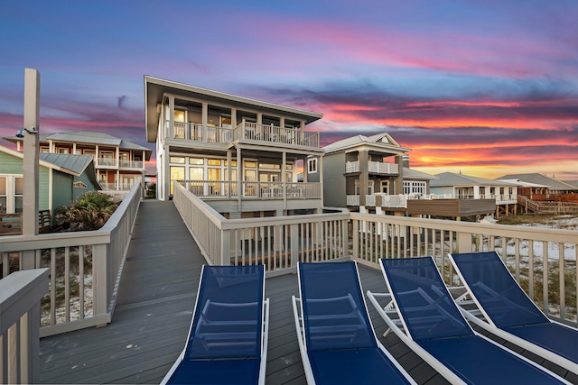 back house at dusk featuring a balcony