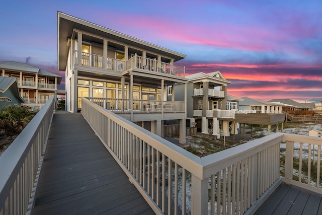 back house at dusk with a balcony