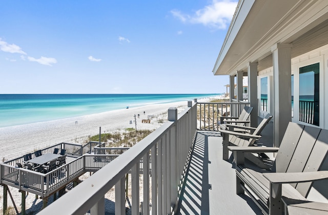 balcony featuring a view of the beach and a water view