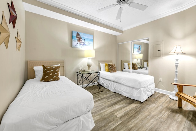 bedroom with hardwood / wood-style floors, a textured ceiling, a closet, and ceiling fan