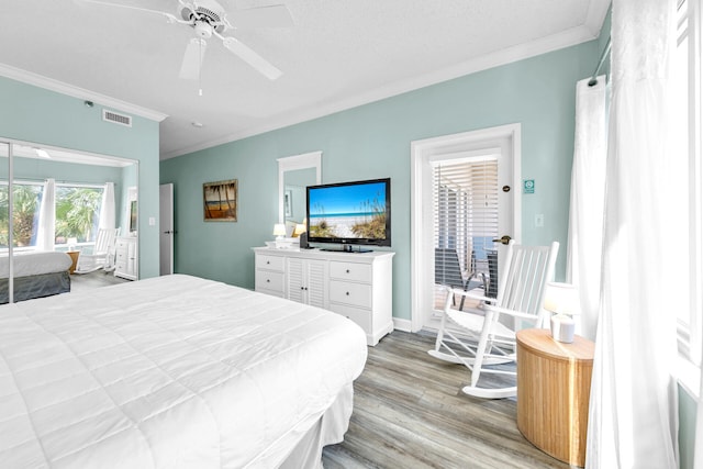 bedroom with ornamental molding, a textured ceiling, light wood-type flooring, and ceiling fan