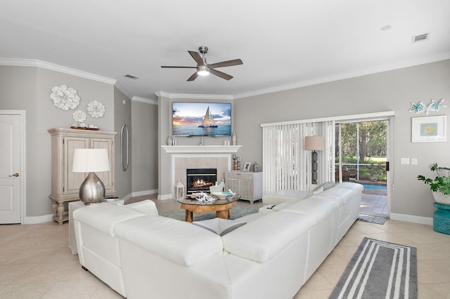 tiled living room featuring ornamental molding, ceiling fan, and a tile fireplace