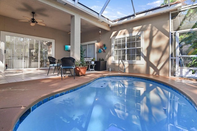 view of pool with ceiling fan, a patio, and a lanai