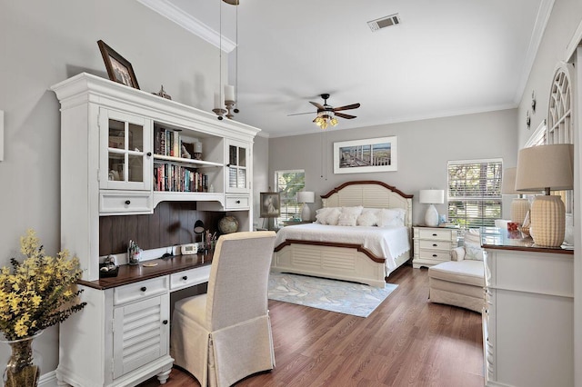 bedroom with ceiling fan, ornamental molding, built in desk, and dark hardwood / wood-style floors