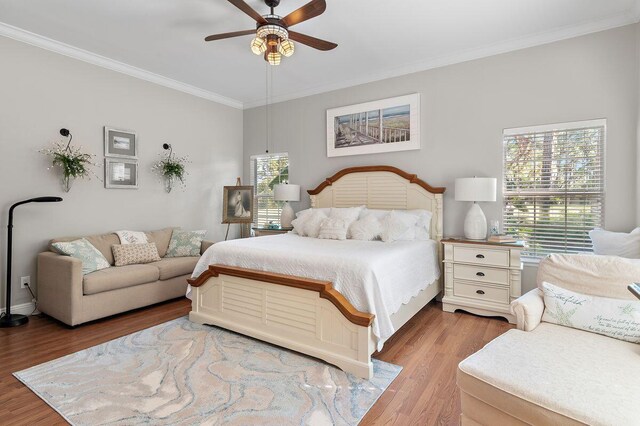 bedroom with ornamental molding, ceiling fan, and light hardwood / wood-style flooring