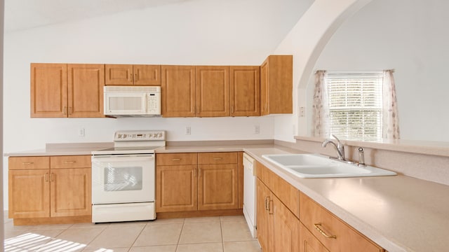 kitchen with lofted ceiling, white appliances, sink, and light tile patterned floors