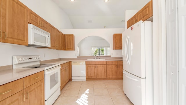 kitchen featuring lofted ceiling, white appliances, sink, and light tile patterned floors