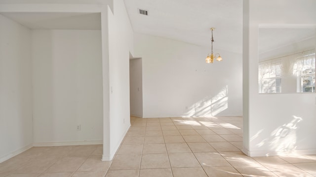 tiled empty room with lofted ceiling and a chandelier