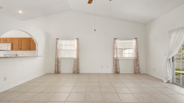 tiled spare room with ceiling fan, plenty of natural light, and high vaulted ceiling