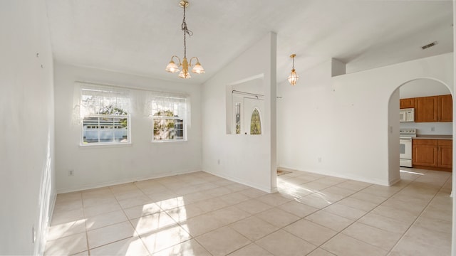 spare room with lofted ceiling, a chandelier, and light tile patterned floors