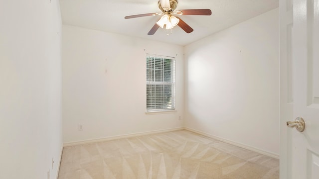 carpeted spare room featuring ceiling fan