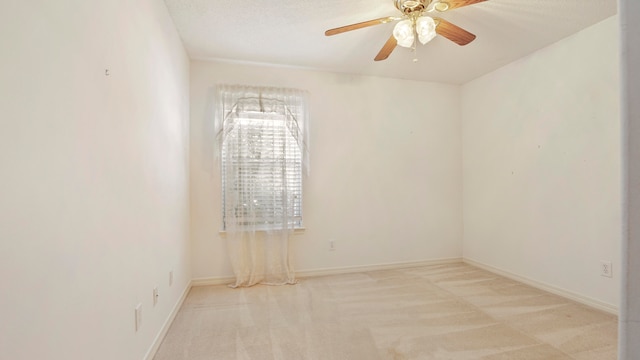 carpeted spare room with ceiling fan and a textured ceiling