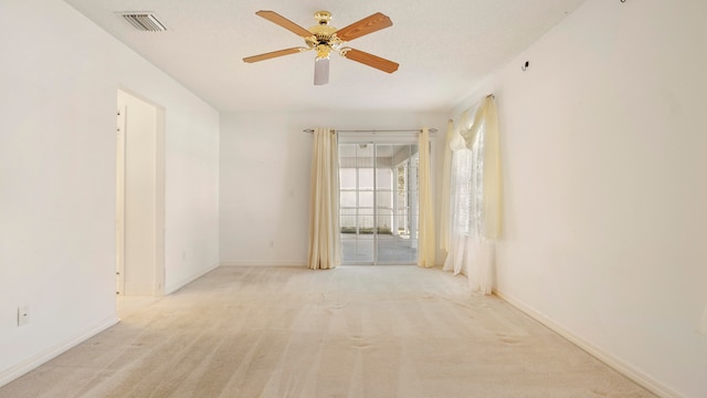 empty room featuring ceiling fan and light colored carpet