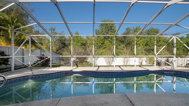 view of swimming pool featuring a patio and a lanai