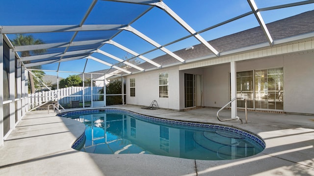 view of pool with glass enclosure and a patio area