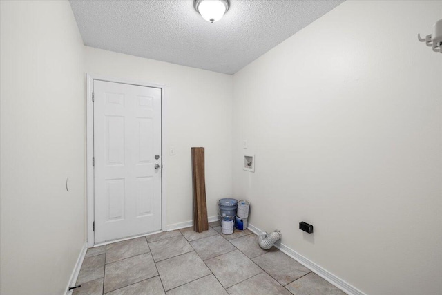 washroom featuring hookup for a washing machine, a textured ceiling, and light tile patterned floors