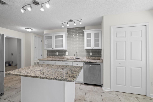 kitchen featuring stainless steel appliances, a center island, sink, and white cabinetry