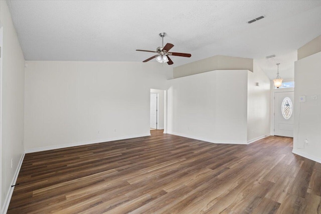 unfurnished living room featuring ceiling fan, vaulted ceiling, a textured ceiling, and dark wood-type flooring