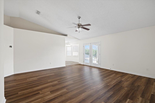 empty room with french doors, a textured ceiling, dark hardwood / wood-style floors, ceiling fan with notable chandelier, and vaulted ceiling