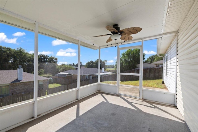 unfurnished sunroom with ceiling fan