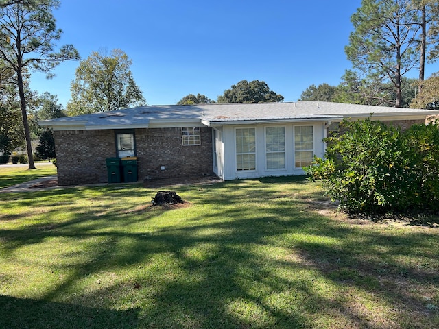 back of property featuring a lawn