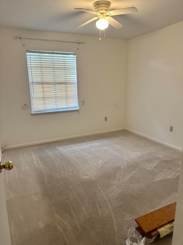 spare room featuring ceiling fan, carpet, and a textured ceiling