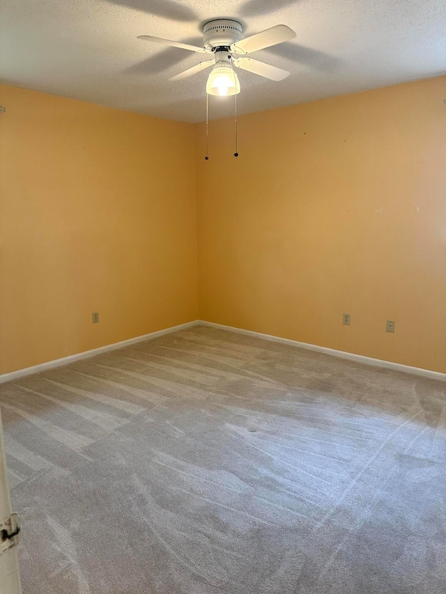 carpeted spare room featuring ceiling fan and a textured ceiling