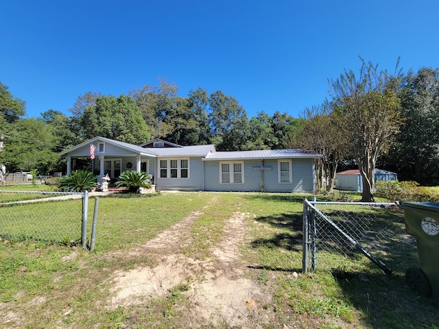 view of front of home featuring a front lawn, fence, and metal roof