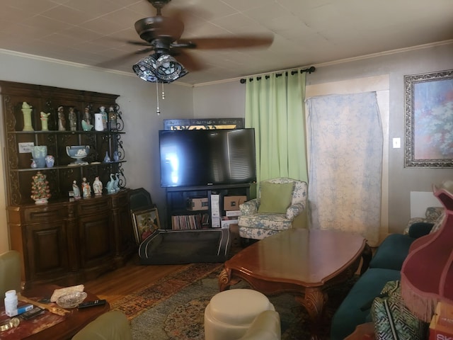 living area featuring crown molding, wood finished floors, and a ceiling fan