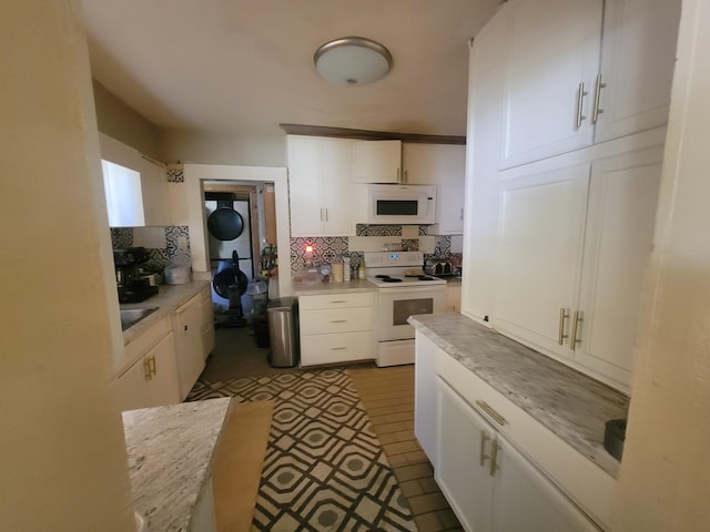 kitchen featuring white cabinetry, white appliances, stacked washer and dryer, and light countertops