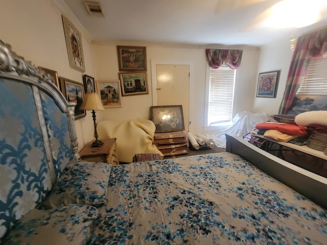 bedroom featuring visible vents and crown molding